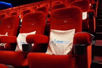 MAEUR-branded cushions on red cinema seats, rows 21 and 22, before an association event